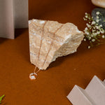 Necklace with a pendant draped over a stone